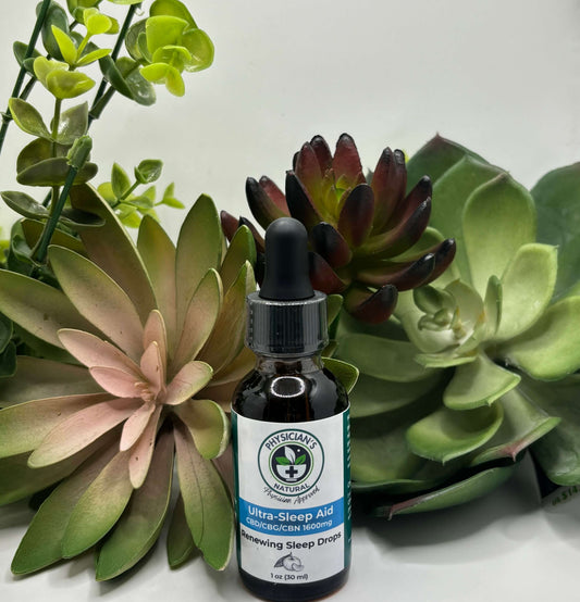 Amber-colored bottle with gradient blue label, 1600 mg CBD, CBG and CBN Ultra-Sleep Aid - Renewing Sleep Drops, surrounded by succulent plants.